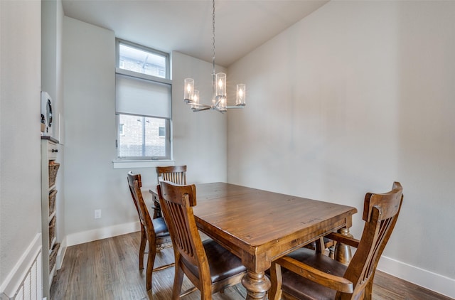 dining area featuring wood-type flooring and an inviting chandelier