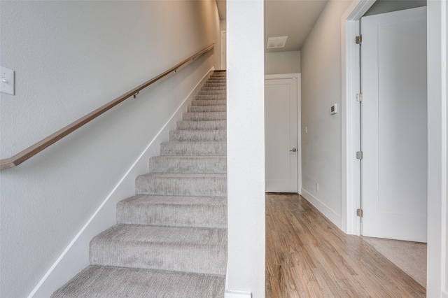 stairway with hardwood / wood-style flooring