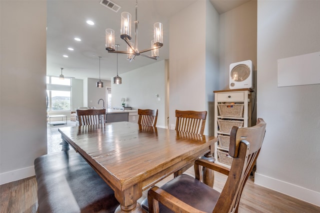 dining area featuring an inviting chandelier and light hardwood / wood-style flooring