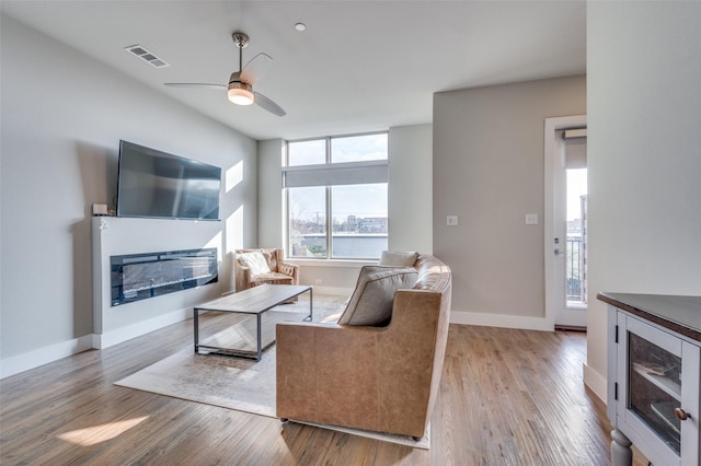 living room featuring ceiling fan and light hardwood / wood-style flooring