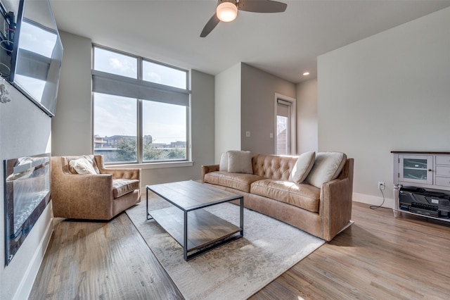 living room with ceiling fan and light wood-type flooring