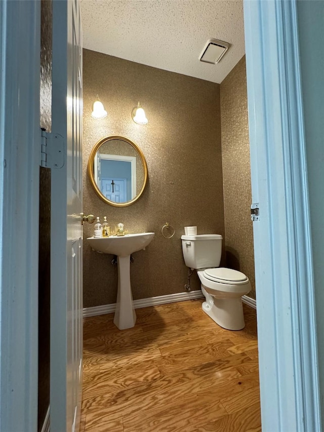 bathroom featuring wood-type flooring and toilet