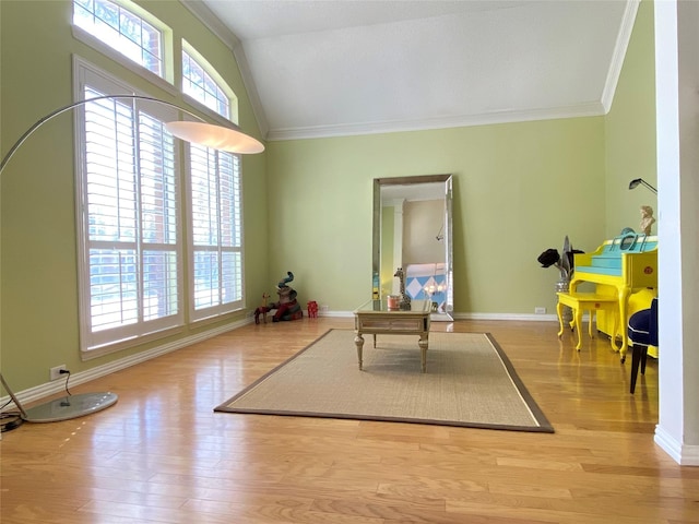 rec room featuring crown molding, vaulted ceiling, and light hardwood / wood-style flooring