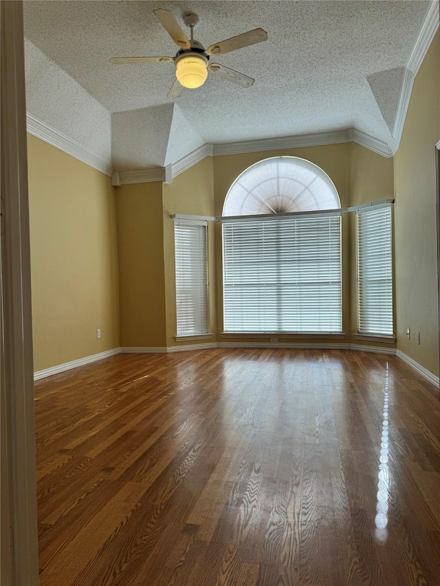 spare room with hardwood / wood-style floors, crown molding, and vaulted ceiling