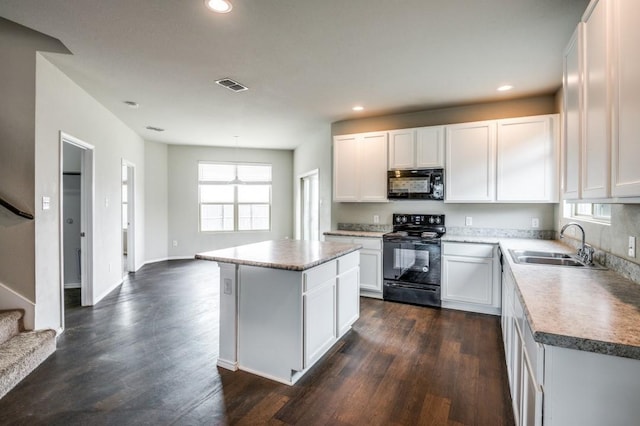 kitchen with dark wood-type flooring, sink, white cabinetry, a kitchen island, and black appliances