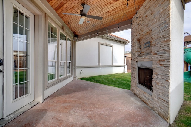 view of patio / terrace with ceiling fan and an outdoor stone fireplace