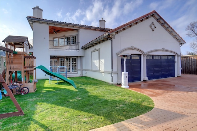 exterior space with a playground, a garage, and a yard