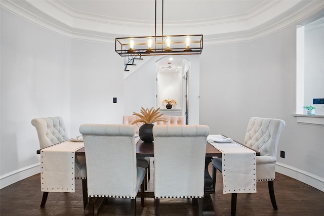 dining space featuring crown molding, dark hardwood / wood-style flooring, and a tray ceiling