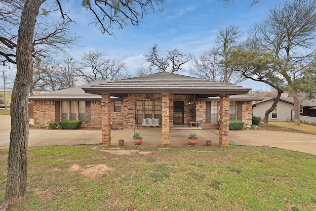 prairie-style home featuring covered porch and a front lawn