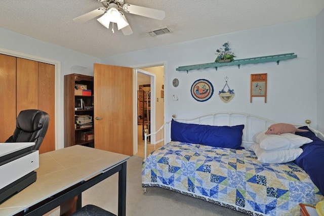 bedroom featuring ceiling fan, a closet, and a textured ceiling