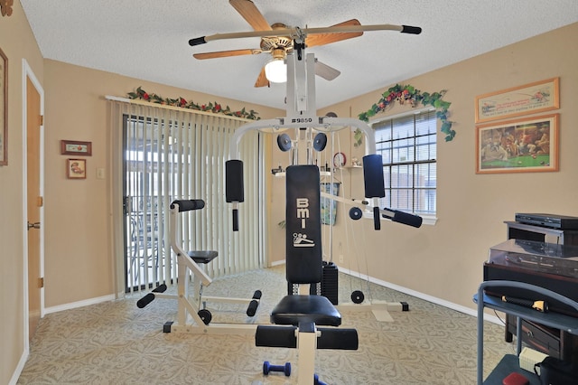 workout area featuring ceiling fan and a textured ceiling