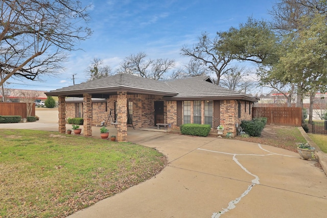 view of front of home featuring brick siding, a front yard, and fence