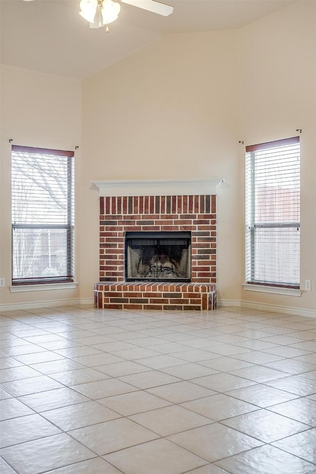 unfurnished living room with lofted ceiling, light tile patterned floors, a fireplace, and ceiling fan