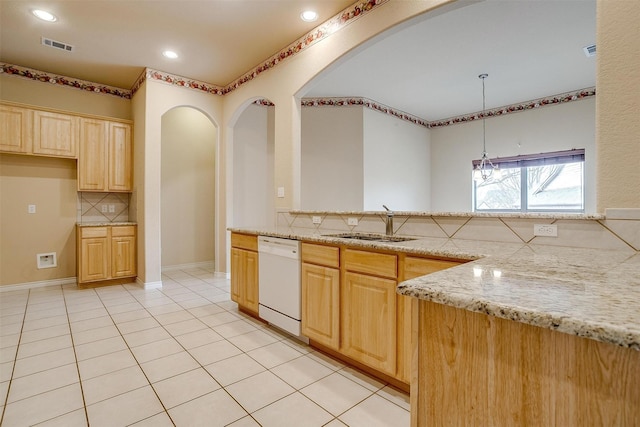 kitchen featuring light brown cabinetry, tasteful backsplash, dishwasher, hanging light fixtures, and light stone countertops