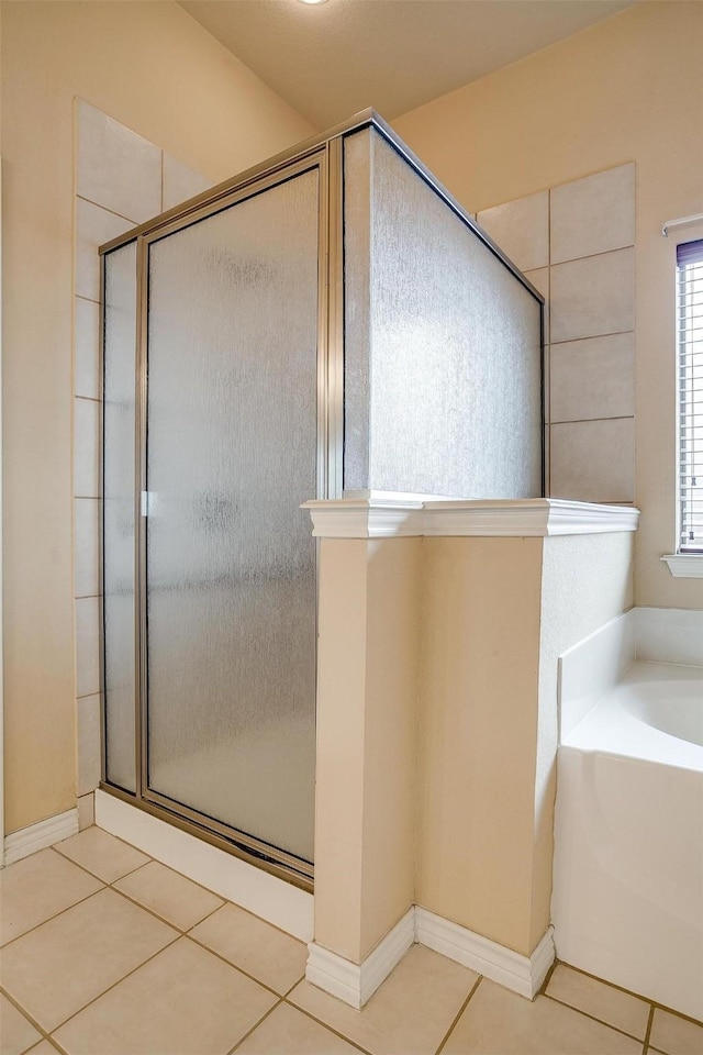 bathroom with tile patterned floors and shower with separate bathtub