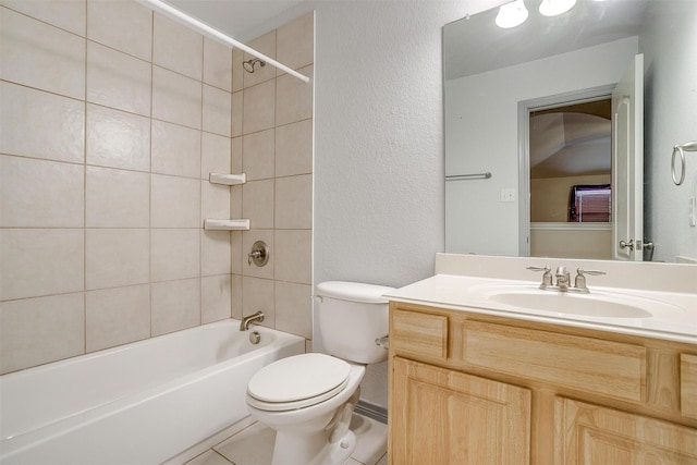 full bathroom featuring tile patterned flooring, tiled shower / bath, vanity, and toilet