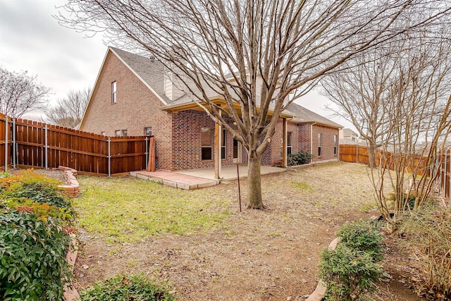 rear view of house featuring a yard and a patio