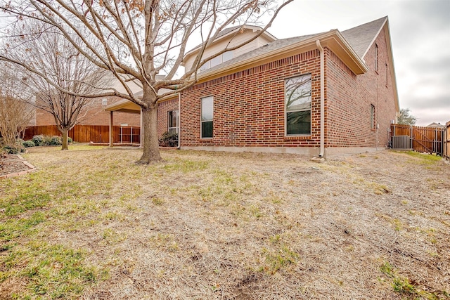 exterior space featuring a yard and central AC