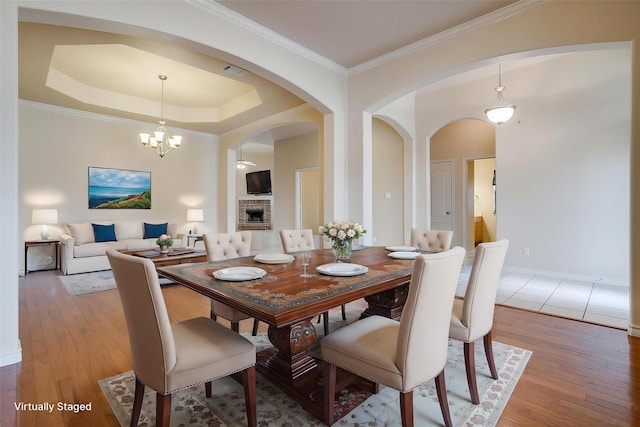 630 Celeste Ln, Burleson, TX 76028 - dining area with arched walkways, light wood-style floors, a chandelier, ornamental molding, and baseboards