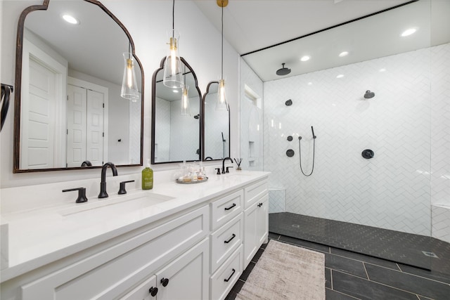 bathroom with tiled shower, vanity, and tile patterned floors