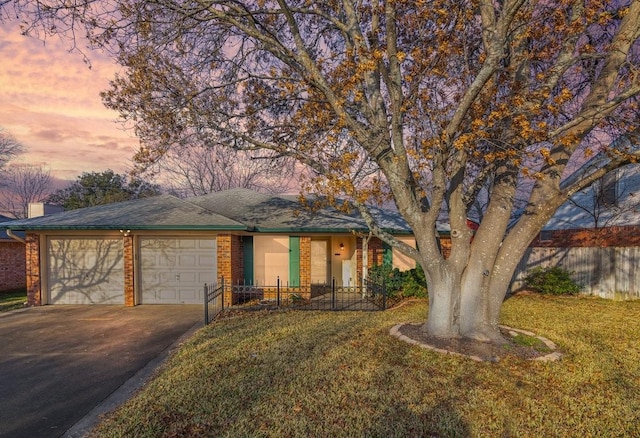 single story home featuring a garage and a lawn