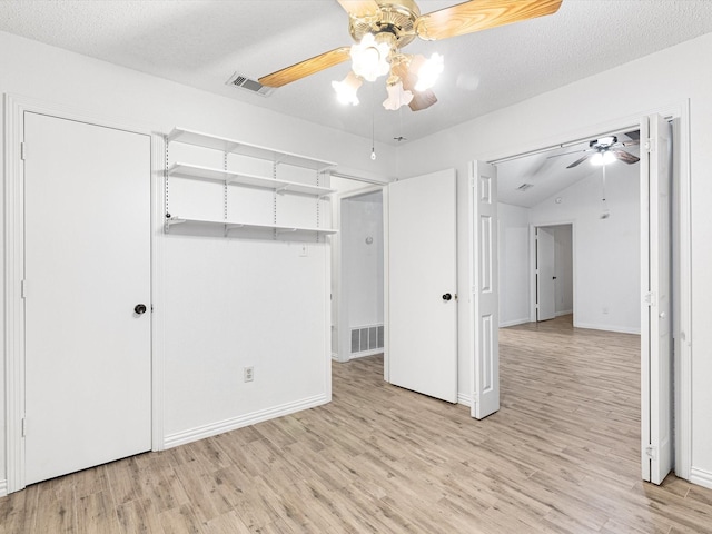 unfurnished bedroom with ceiling fan, light hardwood / wood-style floors, and a textured ceiling