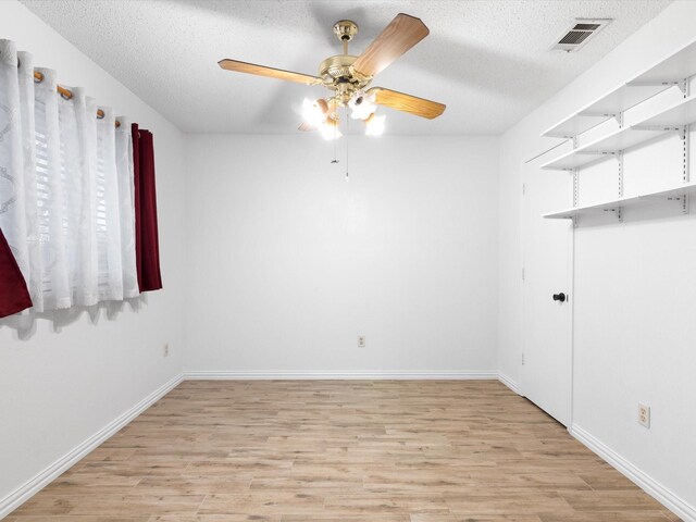 spare room with ceiling fan, a textured ceiling, and light hardwood / wood-style flooring