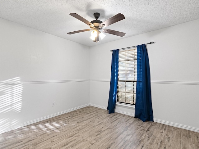 unfurnished room with ceiling fan, a textured ceiling, and light wood-type flooring