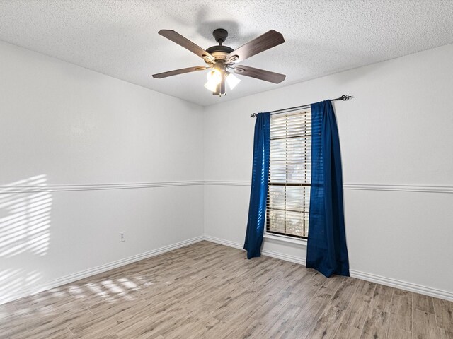 spare room with ceiling fan, light hardwood / wood-style flooring, and a textured ceiling