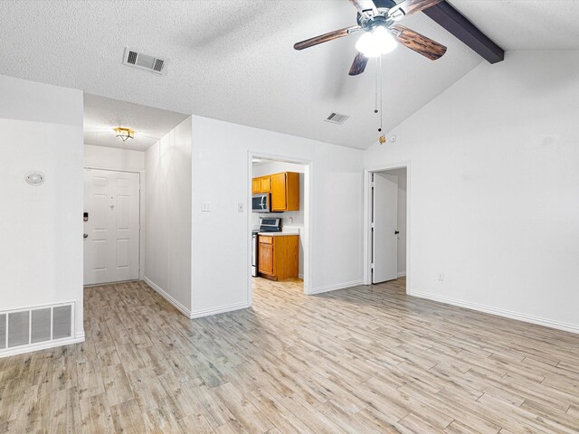 unfurnished living room featuring a tile fireplace, lofted ceiling with beams, ceiling fan, a textured ceiling, and light hardwood / wood-style flooring