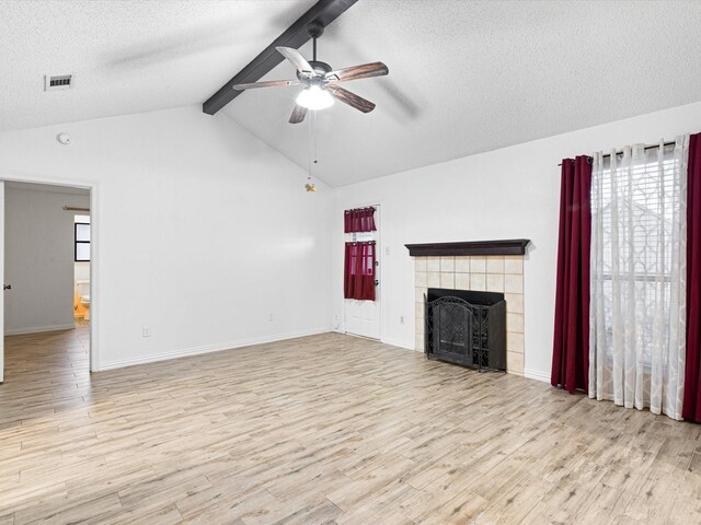 unfurnished bedroom featuring ceiling fan, ensuite bathroom, light hardwood / wood-style floors, a textured ceiling, and a barn door