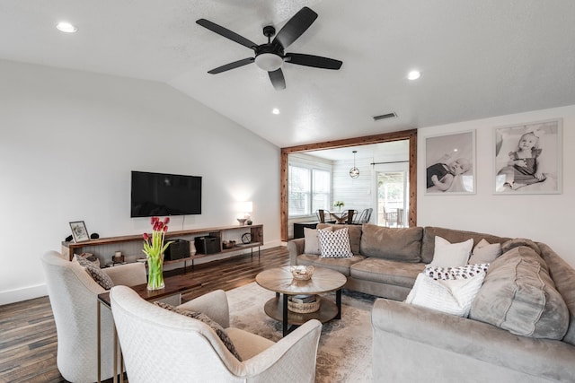 living room with hardwood / wood-style flooring, ceiling fan, and vaulted ceiling