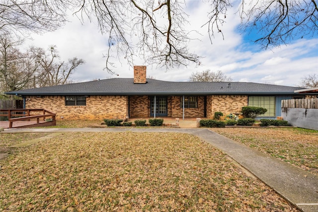 view of front of property with a chimney, a front lawn, and brick siding