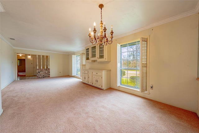 unfurnished living room featuring visible vents, baseboards, light colored carpet, ornamental molding, and a chandelier