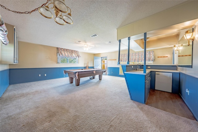 rec room featuring a wainscoted wall, a textured ceiling, dark carpet, and visible vents