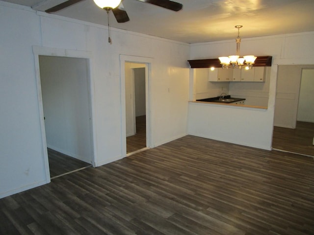 interior space featuring ornamental molding, ceiling fan with notable chandelier, and dark hardwood / wood-style flooring