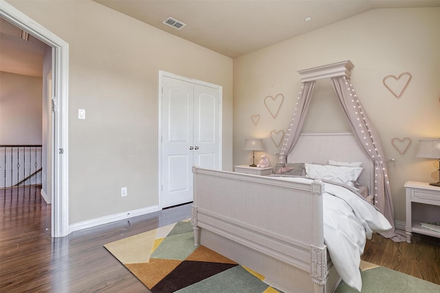 bedroom with lofted ceiling, dark hardwood / wood-style flooring, and a closet