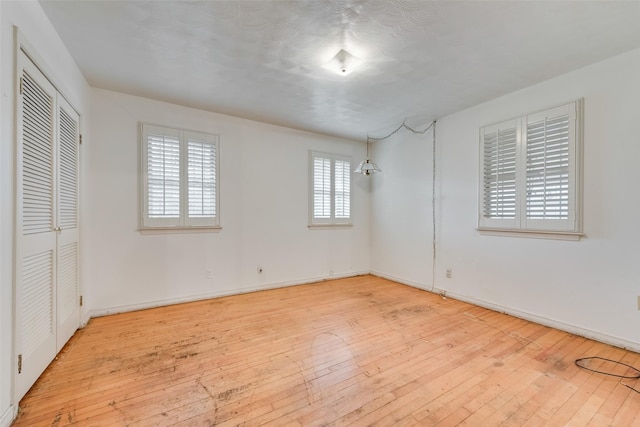 unfurnished bedroom featuring a closet and light wood-type flooring