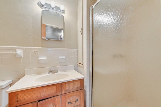 bathroom featuring vanity, an enclosed shower, and tile walls