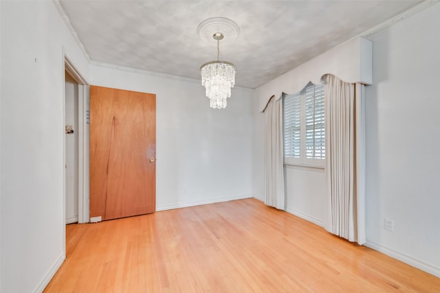 unfurnished room featuring a chandelier and hardwood / wood-style floors