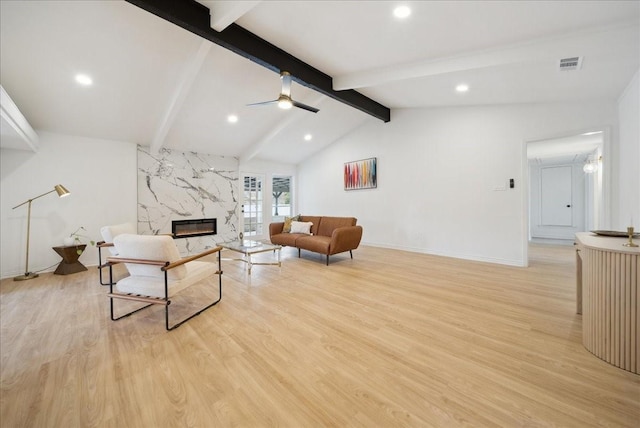 living room featuring a premium fireplace, vaulted ceiling with beams, ceiling fan, and light hardwood / wood-style flooring