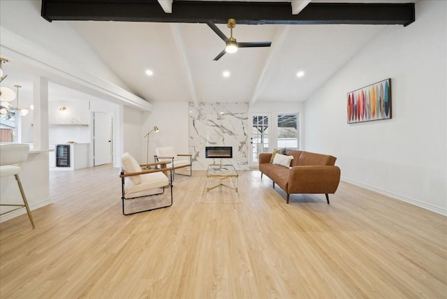 living room with wine cooler, lofted ceiling with beams, ceiling fan, a high end fireplace, and light hardwood / wood-style floors