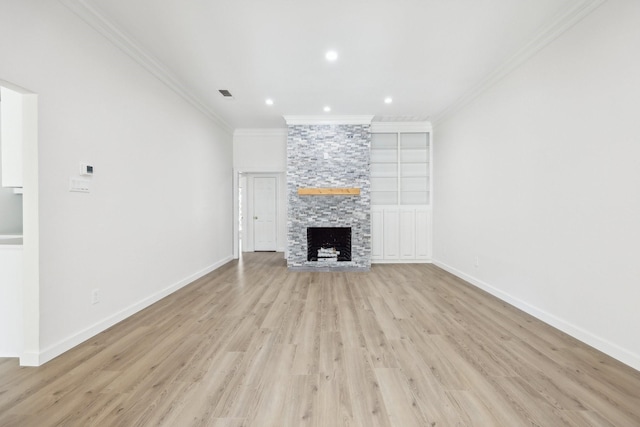 unfurnished living room with crown molding, visible vents, a fireplace, and baseboards