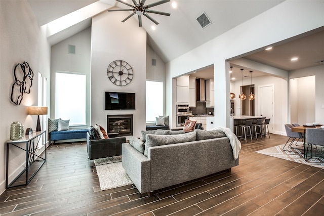 living room with a large fireplace, a notable chandelier, visible vents, and wood tiled floor