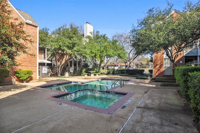 view of swimming pool featuring a hot tub