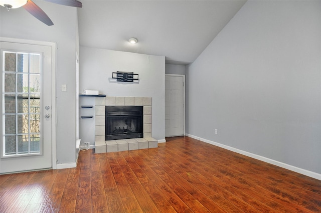 unfurnished living room featuring a tile fireplace, vaulted ceiling, hardwood / wood-style floors, and ceiling fan