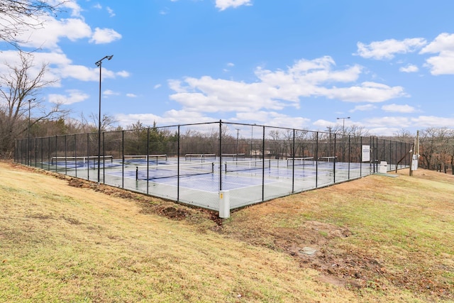 view of tennis court featuring a yard