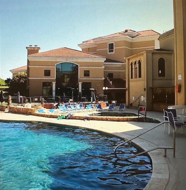 back of house featuring a pool with hot tub and a patio area