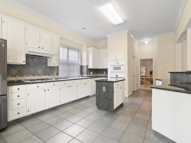 kitchen featuring light tile patterned floors, white gas stovetop, white cabinets, and a kitchen island