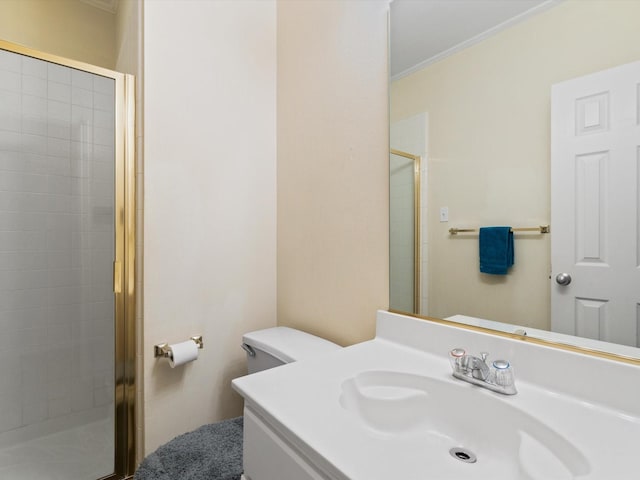 bathroom with vanity, a shower with shower door, ornamental molding, and toilet